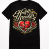 Black streetwear T-shirt featuring the Heart Breaker graphic with gold script lettering, cracked red heart, barbed wire, and roses by Merch By Mike